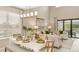 Open-concept dining area with a stylish chandelier, leading into a bright living room with outdoor views at 719 Steel Dr, Apollo Beach, FL 33572
