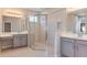 Bright bathroom featuring double vanity with gray cabinets and large glass-enclosed shower at 720 Sky Shade Dr, Apollo Beach, FL 33572