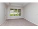 Neutral bedroom with carpet, tray ceiling and a large window with blinds at 720 Sky Shade Dr, Apollo Beach, FL 33572