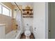Second view of bathroom featuring a bathtub with shower and rustic shelving at 759 Lantana Ave, Clearwater Beach, FL 33767