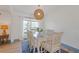 Bright dining room featuring a classic table with upholstered chairs, a wicker pendant light, and a sunny window at 759 Lantana Ave, Clearwater Beach, FL 33767