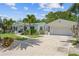 Charming home featuring a lovely landscaped yard, palm trees, and a welcoming front entrance and attached garage at 759 Lantana Ave, Clearwater Beach, FL 33767