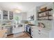 Bright kitchen with white cabinets, stainless steel appliances, and decorative tile backsplash at 759 Lantana Ave, Clearwater Beach, FL 33767