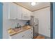Compact kitchenette featuring white cabinets, stainless steel appliances, and wood countertop at 759 Lantana Ave, Clearwater Beach, FL 33767