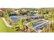 Aerial view showcasing tennis and bocce ball courts, community landscaping and nearby residences at 8605 Grand Alberato Rd, Tampa, FL 33647