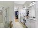 Bright bathroom featuring double vanity, granite countertops, and a glass-enclosed shower with linen closet at 8605 Grand Alberato Rd, Tampa, FL 33647