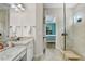 Bright bathroom featuring double vanity, granite countertops, and a glass-enclosed shower with an open closet at 8605 Grand Alberato Rd, Tampa, FL 33647