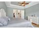 Comfortable bedroom with tray ceiling, and stylish furnishings, with ensuite closets at 8605 Grand Alberato Rd, Tampa, FL 33647