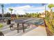 Community bocce ball court with metal picnic tables and lush tropical landscaping at 8605 Grand Alberato Rd, Tampa, FL 33647