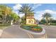 View of the landscaped entry gate to the community, with colorful flowerbeds at 8605 Grand Alberato Rd, Tampa, FL 33647