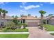 Beautiful single-story home featuring a brick driveway, lush landscaping, and a classic tile roof at 8605 Grand Alberato Rd, Tampa, FL 33647