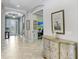 Bright hallway featuring tile flooring and neutral paint, flowing into the office and other living spaces at 8605 Grand Alberato Rd, Tampa, FL 33647