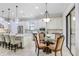 Stylish kitchen with white cabinetry, stainless appliances, large island with bar stool seating, and adjacent dining area at 8605 Grand Alberato Rd, Tampa, FL 33647