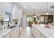 Bright kitchen with stainless steel appliances, white cabinets, granite counters, and a view to the outdoor space at 8605 Grand Alberato Rd, Tampa, FL 33647