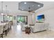 Open floor plan living room with tiled floor, modern ceiling fan, and slider to the outdoor patio at 8605 Grand Alberato Rd, Tampa, FL 33647