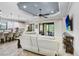 Bright living room with white sofa, large screen tv, and adjacent eat-in kitchen at 8605 Grand Alberato Rd, Tampa, FL 33647
