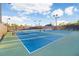 View of fenced community tennis courts with blue playing surface at 8605 Grand Alberato Rd, Tampa, FL 33647