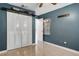 A blue bedroom featuring a closet, neutral tile flooring, and a ceiling fan at 915 S Miller Rd, Valrico, FL 33594