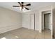 Bedroom featuring bi-fold closets, tile floors, and a ceiling fan, offering comfort and functionality at 915 S Miller Rd, Valrico, FL 33594