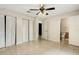 Spacious bedroom featuring bi-fold closets, tile floors, a ceiling fan, and access to an ensuite bathroom at 915 S Miller Rd, Valrico, FL 33594