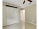 This bedroom includes a closet, neutral tile floor, and an adjoining bathroom at 915 S Miller Rd, Valrico, FL 33594