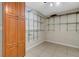 A closet features tile floors, metal shelving for storage, and a wooden cabinet for clothing at 915 S Miller Rd, Valrico, FL 33594