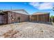 Exterior view showing building and carport, with a gravel area, and a glimpse of the surrounding landscape at 915 S Miller Rd, Valrico, FL 33594