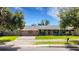Cozy single story home featuring a red front door, green lawn, and mature trees at 915 S Miller Rd, Valrico, FL 33594