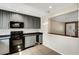 Bright kitchen with gray cabinets, black appliances, and a serving hatch at 915 S Miller Rd, Valrico, FL 33594