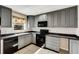 Updated kitchen with sleek, gray cabinetry, modern appliances, and subway tile backsplash at 915 S Miller Rd, Valrico, FL 33594