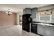 Eat-in kitchen featuring stylish gray cabinets, black appliances, and tile flooring at 915 S Miller Rd, Valrico, FL 33594