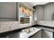 Kitchen featuring a stainless steel sink, gray cabinetry, and a floral window curtain at 915 S Miller Rd, Valrico, FL 33594