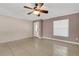 An open living room with tile floors features a ceiling fan, a white front door, and a window at 915 S Miller Rd, Valrico, FL 33594