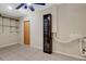 A room with tile floors, metal shelving, a wooden door, a ceiling fan, and a cabinet with shelves at 915 S Miller Rd, Valrico, FL 33594