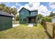 View of a two-story home with a green exterior, a well-kept lawn, and a detached garage at 101 E Lambright St, Tampa, FL 33604