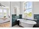 Bright bathroom featuring a freestanding tub with elegant gold fixtures and stylish green tiling at 101 E Lambright St, Tampa, FL 33604