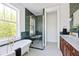 Elegant bathroom with a soaking tub, glass shower, and wood vanity with marble countertop and emerald green tiling at 101 E Lambright St, Tampa, FL 33604