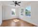 Bright bedroom features hardwood floors, a ceiling fan, and large windows with lush backyard views at 101 E Lambright St, Tampa, FL 33604