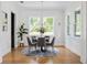 Bright dining room with hardwood floors, modern chandelier, a round table with seating for four, and natural light at 101 E Lambright St, Tampa, FL 33604