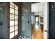 Inviting entryway with charming details: decorative wallpaper, wooden door with windows and contrasting black and white tile flooring at 101 E Lambright St, Tampa, FL 33604