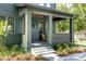 Inviting front porch of home with wood ceiling, Adirondack chair, and well maintained yard at 101 E Lambright St, Tampa, FL 33604