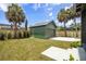 Backyard view of a matching detached garage with palm trees and a driveway leading to the house at 101 E Lambright St, Tampa, FL 33604