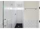 Sleek shower featuring white subway tiles, a glass door, and a black hexagon tile floor at 101 E Lambright St, Tampa, FL 33604