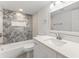 Beautiful bathroom features modern fixtures, a white vanity, and uniquely tiled bathtub and shower at 10237 Carrin Rd, Spring Hill, FL 34608