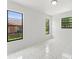 Bright, open bedroom with large windows offering plenty of natural light and modern tile flooring at 10237 Carrin Rd, Spring Hill, FL 34608