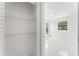 Open bedroom closet featuring plenty of storage space with wire racks, leading to a bedroom with plenty of natural light at 10237 Carrin Rd, Spring Hill, FL 34608