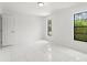 Bright, spacious bedroom with plenty of natural light and modern tile flooring at 10237 Carrin Rd, Spring Hill, FL 34608