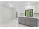Modern kitchen features stainless steel appliances and gray cabinets, with backyard views from the window at 10237 Carrin Rd, Spring Hill, FL 34608