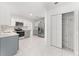 Bright, open kitchen with stainless steel appliances, gray cabinets and white marble flooring at 10237 Carrin Rd, Spring Hill, FL 34608