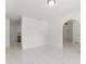 Spacious living room featuring modern tile flooring, white walls, and openings to the kitchen and bedrooms at 10237 Carrin Rd, Spring Hill, FL 34608